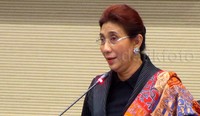 Berbaju serba hitam dengan selendang di bahu sisi kirinya, Susi berbicara dalam bahasa inggris dengan penuh percaya diri di depan para peserta.