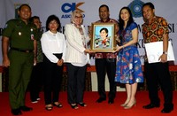 Veronica Tan menerima lukisan dari perwakilan PT Askrindo Dewi Agustina.
