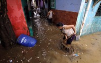 Mereka terlihat sibuk membersihkan rumah mereka dari lumpur.