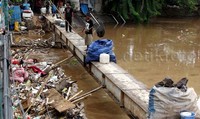 Warga mencari botol plastik yang terbawa aliran sungai.