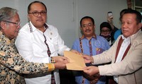 Perwakilan biro hukum Kementerian ESDM, Hufron menyerahkan amplop berwarna cokelat kepada Wakil Ketua MKD Junimart Girsang dan Hardi Susilo. Pool/Lamhot Aritonang/detikFoto.