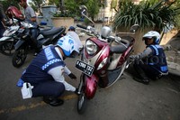 Dua orang petugas Dishub mencabut pentil kendaraan bermotor.