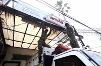 Petugas menurunkan reklame rokok.