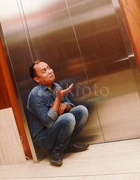 Lalu Azis berpose jongkok di depan lift. Pool/Gus Mun/detikFoto.