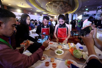 Seorang SPG memotong buah menjadi beberapa bagian di atas layar Zenfone Max.
