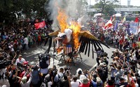     Demonstran membakar patung elang. Cheryl Gagalac/Reuters/detikFoto.