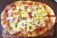 Pizza ayam balado berbentuk oval memanjang dengan dengan diameter sekitar 15 cm. Di atasnya diberi lapisan keju, potongan fillet ayam, daun bawang, dan sambal merah. Huahh! Rasanya pedas menggugah selera.