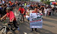 Relawan KNRP menggunakan Walkingboard event Palestine Solidarity Day sekaligus menyosialisasikan dengan selebaran yang diambil oleh warga yang melintas. (Istimewa/Dok.KNRP).