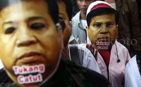 Massa memakai topeng Ketua DPR Setya Novanto.