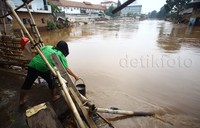 Seorang warga mengambil air dari Kali Ciliwung.
