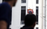 Petugas memperagakan proses evakuasi penghuni gedung.