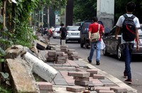 Beberapa warga terpaksa melintas di badan jalan karena trotoar masih dalam perbaikan.