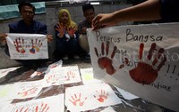 Kain-kain yang catnya sudah kering akan dijahit dan dibentangkan di alun-alun Bandung untuk memperingati Hari Anti Korupsi.