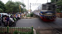 Para pengendara mengantre di depan pintu perlintasan KA.