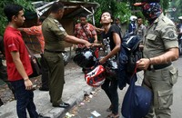 Warga berusaha menyelamatkan helmnya.