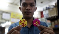 Seorang pekerja menunjukan pin di salah satu tempat pembuatan pin di kawasan Blok M Square.