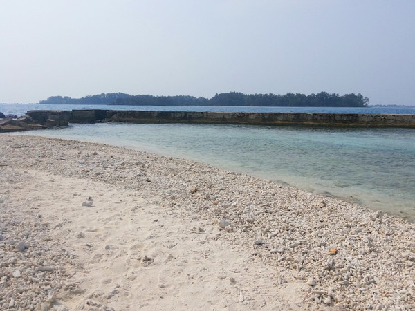 Di sekeliling Pulau Bulat, ada semacam tanggul batu yang bisa memecah ombak besar. Jadi wisatawan bisa santai berenang di area pantainya (Kurnia/detikTravel)