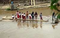 Para siswa yang tinggal di Kampung Pulo itu menyeberangi sungai menuju sekolahnya di kawasan Bukit Duri.