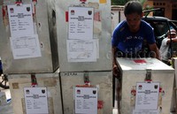 Seorang petugas menurunkan kotak suara yang masih disegel. Pool/Lamhot Aritonang/detikFoto.