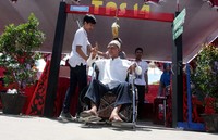 Seorang warga yang tampak menggunakan kursi roda menunjukan jari kelingkingnya yang telah dicelup tinta tanda sudah mencoblos. Pool/Lamhot Aritonang/detikFoto.