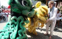  Seorang peninjau asing tampak mendapat hiburan dari aksi barongsai di TPS 12, Cilenggang, Tangsel.