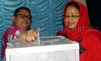 Yuni Satia Rahayu dan suaminya memasukkan surat suara.