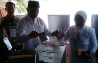 Rasiyo memasukkan surat suara ke kotak suara.