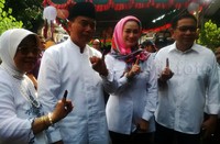 Rasiyo dan keluarga menunjukkan jari yang telah dicelupkan ke tinta.
