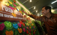 Menkopolhukan Luhut Binsar Pandjaitan menempelkan kertas bertuliskan harapan di dinding pohon harapan.