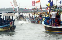 Para nelayan melarung sesaji ke tengah laut.