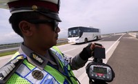 Seorang polisi menunjukkan kecepatan bus yang melintas di tol Cipali. Ist/dok Tol Cipali.