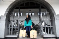 Calon penumpang membawa barang bawaan berupa tas besar dan kardus.