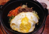 Bulgogi Dolsot Bibimbap berisi topping sayuran, bulgogi dan telur tersaji dalam mangkuk hitam tahan panas (dolsot). Bulgogi dari daging yang empuk lembut bercitarasa manis dan beraroma minyak wijen.