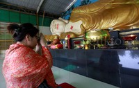 Seorang pengunjung tampak sedang berdoa di depan patung Biddha tidu raksasa di Vihara Buddha Dharma dan 8 Pho Sat, Bogor, Selasa (15/12/2015).