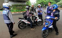 Sejumlah petugas Dishub DKI Jakarta dibantu oleh petugas TNI melakukan penghadangan kepada pengendara motor yang melawan arus lalu lintas.