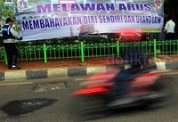 Petugas memasang spanduk bahaya melawan arus.