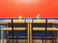 Uniknya, bangku dan meja di tempat ini berkaki tinggi. Cat ruangannya didominasi merah dan biru.