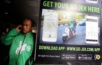 Driver Go-Jek tampak sedang menghubungi penumpang.