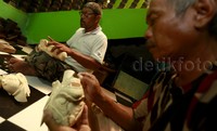 Perajin sedang mengukir bahan kayu hingga membentuk kepala salah satu tokoh wayang golek di Sanggar Tumaritis, Bogor, Rabu (15/12/2015).