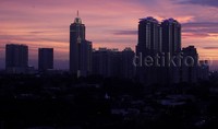 Lanskap gedung tinggi yang menjadi siluet menambah dramatis suasana sebelum matahari benar-benar ditelan horizon.