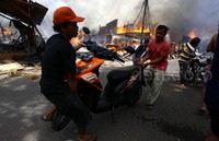 Angin yang kencang membuat api semakin besar.