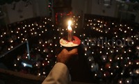 Umat Kristiani menyalakan lilin saat melaksanakan ibadah malam Natal.