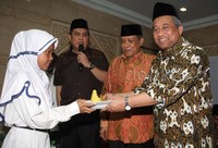 M Nuh memberikan potongan tumpeng kepada salah satu perwakilan anak Yatim. (Foto: Lamhot Aritonang/detikcom)