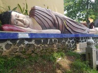 Pakaiannya tampak berwarna coklat tua. Di bagian depan patung dibuat sebuah tempat untuk berdoa (Kurnia/detikTravel)