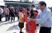 Rizal Ramli disambut murid sekolah dasar saat akan menebar bibit ikan di desa Luman Gaoul, Kecamatan Balige, Toba Samosir, Sumatera Utara. Pool/Kemenko Maritim.