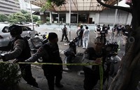 Anggota polisi memasang garis polisi di gedung tersebut.     