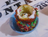 Roti berbentuk pipa diolesi dengan ovomaltine dan taburan fruity pebbles dan meisjes.