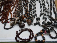 Kalung berwarna hitam itu dibuat dari biji pisang. Untuk kalung dan gelang yang terdiri dari biji kecoklatan yang lebih pipih, dibuat dari biji lamtoro (Kurnia/detikTravel)