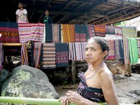Seorang mama yang berdagang di Kampung Takpala, namanya Kaleopatra. Ia berjualan sambil mengenakan pakaian adat setempat (Kurnia/detikTravel)