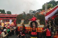 Bima Arya pun naik ke atas kepala Reog. Kepala Reog yang dihiasi bulu merak ini diangkat oleh satu orang. Bisa dibayangkan betapa berat yang harus disangga ketika Walikota Bogor naik di atasnya (Wahyu/detikTravel)